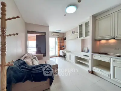 Charming living room with cozy sofa and modern kitchen in open layout apartment.