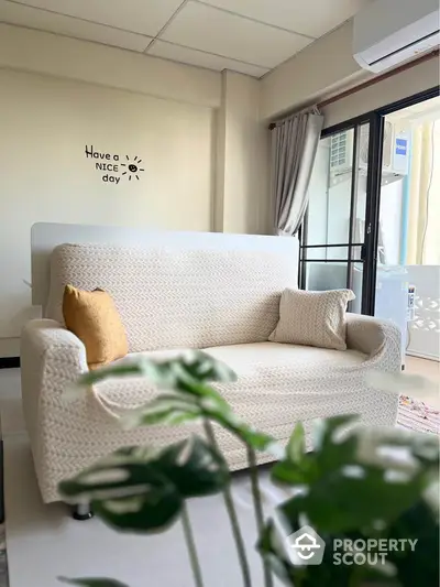 Cozy living room with stylish sofa and natural light from large window