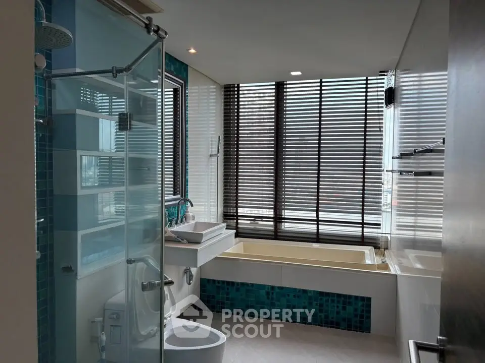 Luxurious bathroom with modern fixtures and large windows offering natural light.