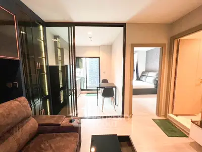 Modern apartment interior with living room, dining area, and bedroom view.