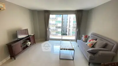 Modern living room with large window and stylish furniture in a high-rise apartment.