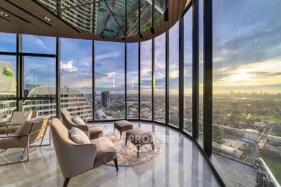 Luxurious corner unit with panoramic city views and elegant seating area in high-rise building.