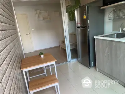 Modern compact kitchen with stainless steel fridge and cozy dining area