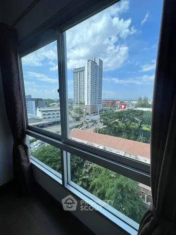 Stunning cityscape view from a high-rise apartment window, showcasing urban living with lush greenery.
