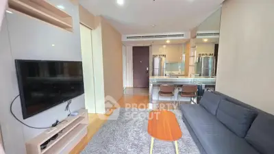 Modern living room with sleek furniture and open kitchen layout in a stylish apartment.