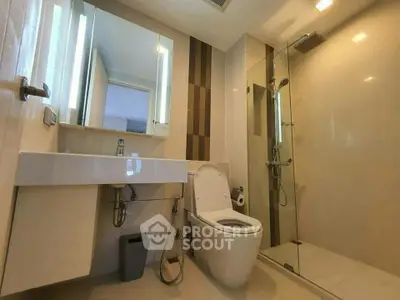 Modern bathroom with sleek design featuring a glass shower and contemporary fixtures.