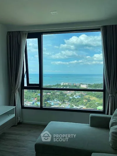Stunning high-rise living room with panoramic ocean view through large window.