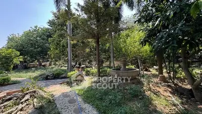 Lush garden with mature trees and stone pathway in serene setting