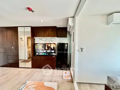 Modern living room with sleek wooden cabinetry and built-in TV unit