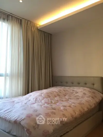 Cozy bedroom with soft lighting and elegant curtains, perfect for relaxation.
