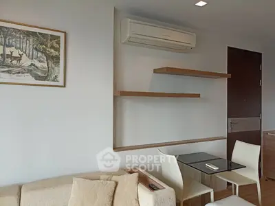 Modern living room with minimalist decor, featuring a cozy sofa, wall-mounted shelves, and a sleek air conditioner.