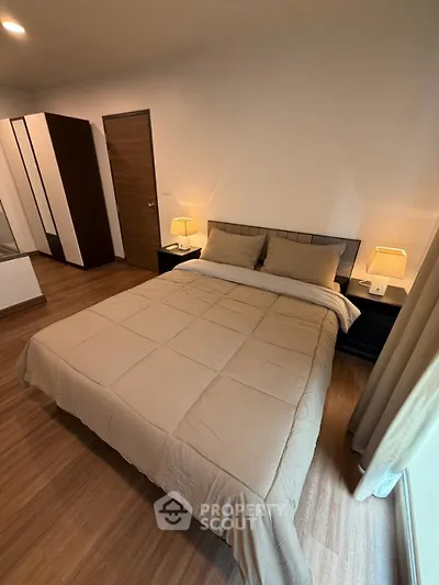 Cozy bedroom with modern decor and warm lighting, featuring a comfortable bed and stylish furnishings.
