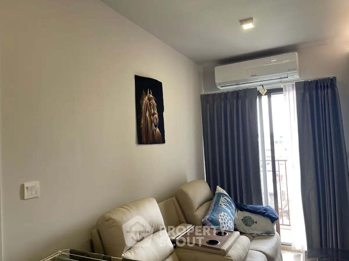 Modern living room with cozy seating and air conditioning, featuring a horse painting and balcony access.