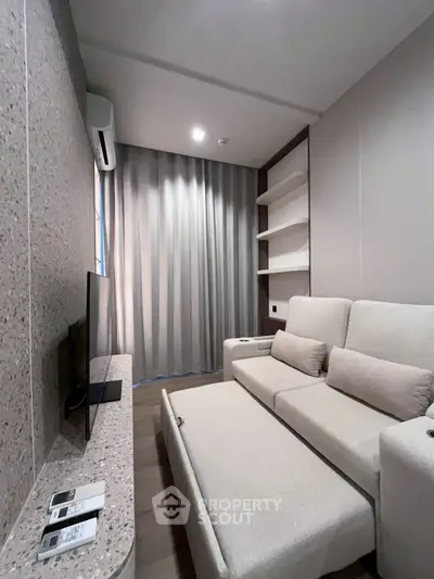 Modern living room with sleek design and neutral tones, featuring a comfortable sofa and built-in shelves.