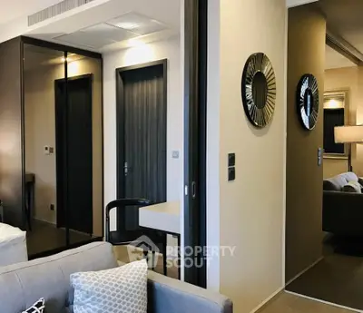 Modern living room with stylish decor and mirrored closet doors in a cozy apartment.