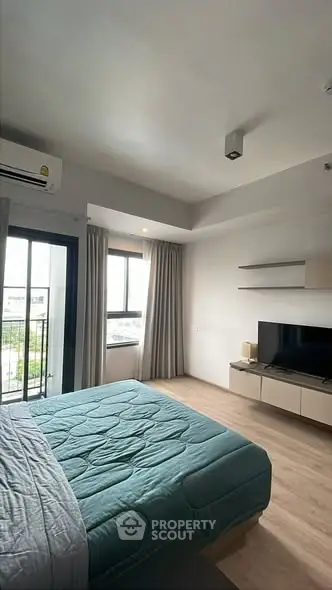Modern bedroom with balcony access and stylish decor in a contemporary apartment.