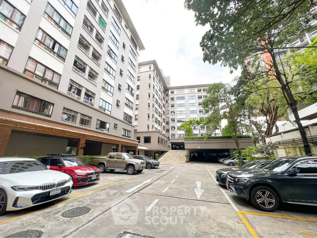 Spacious urban apartment complex with ample parking and modern architecture.