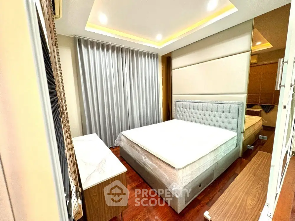 Modern bedroom with elegant design, featuring a plush bed, stylish furniture, and ambient lighting.