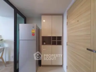 Modern kitchen with sleek cabinetry and stainless steel fridge in a stylish apartment.