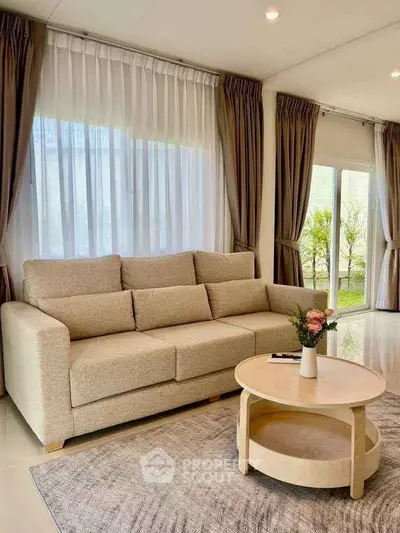 Elegant living room with beige sofa and large windows, perfect for relaxation.