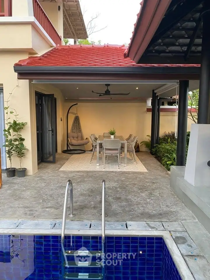 Charming outdoor dining area with poolside view and modern furnishings in a stylish home.