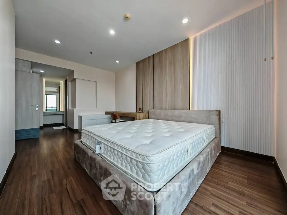 Spacious modern bedroom with elegant wooden flooring and stylish decor