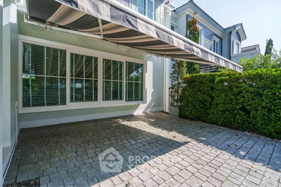 Charming residential exterior with paved driveway and lush greenery, perfect for modern living.