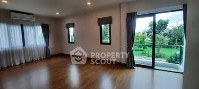 Spacious living room with large windows and garden view, perfect for natural light lovers.