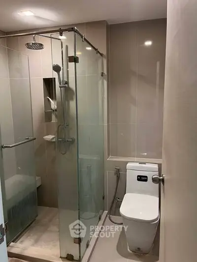 Modern bathroom with glass shower enclosure and sleek fixtures.