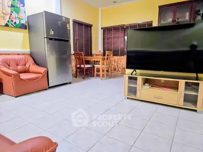 Spacious living room with modern furniture and large TV, perfect for relaxation.