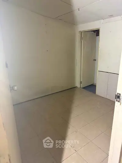 Compact room with tiled floor and plain walls, ideal for storage or utility use.