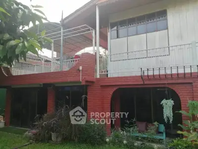 Charming two-story brick house with lush garden and spacious balcony.