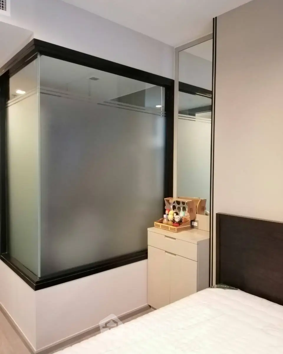 Modern bedroom with frosted glass partition and sleek furniture design