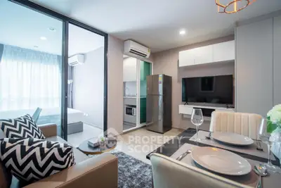 Modern open-plan living room with stylish kitchen and dining area in a chic apartment.