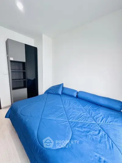 Cozy bedroom with blue bedding and modern wardrobe, perfect for relaxation.