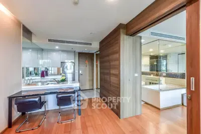 Modern open-layout kitchen with sleek design and wooden flooring in a stylish apartment.