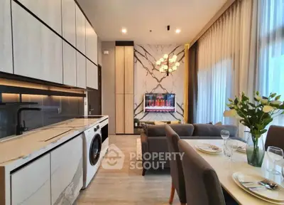 Modern open-plan kitchen and living room with elegant decor and natural light.