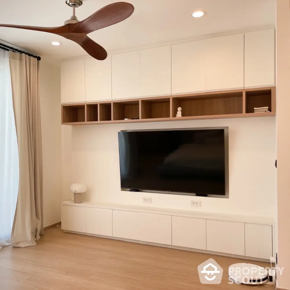 Modern living room with built-in entertainment center and sleek ceiling fan