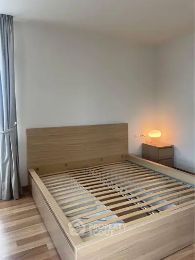 Modern bedroom with wooden bed frame and soft lighting, perfect for a cozy retreat.