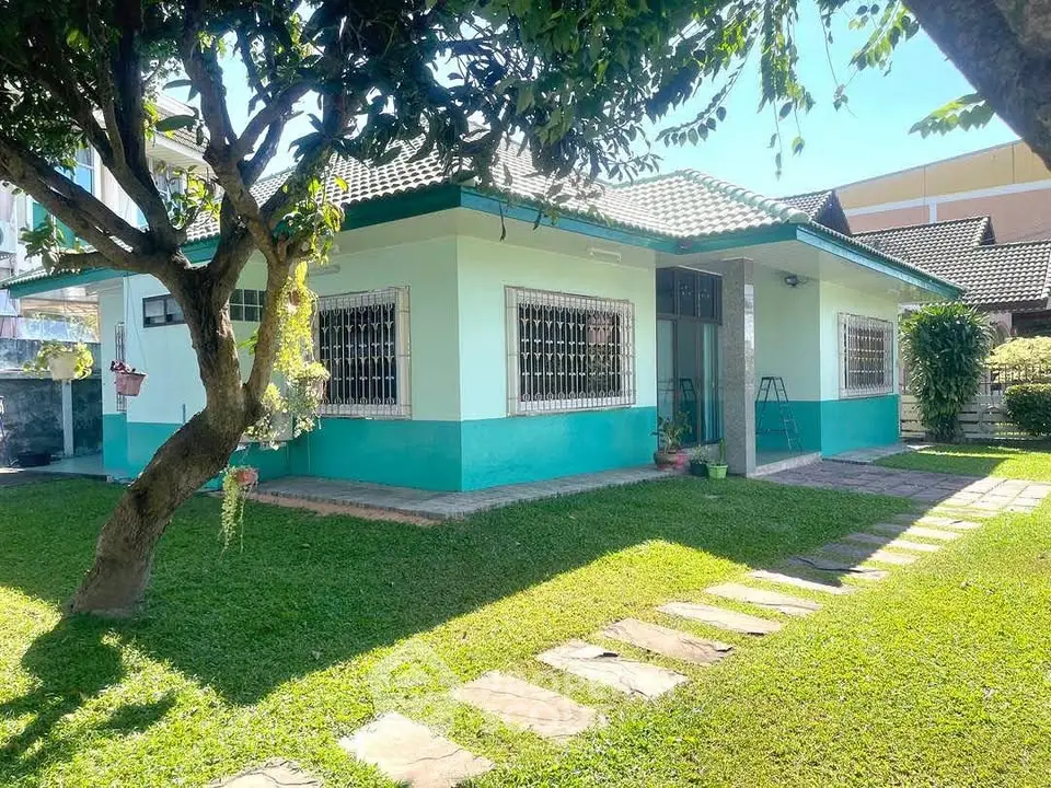 Charming single-story home with lush garden and inviting pathway, perfect for serene living.