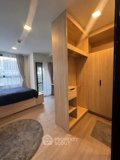 Modern bedroom with walk-in closet and large windows in a stylish apartment.