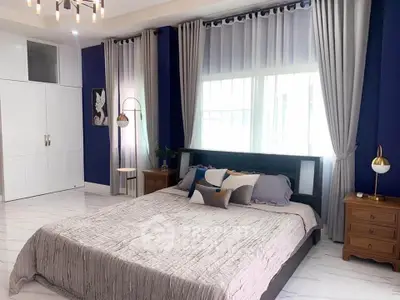 Spacious bedroom with elegant decor and large windows for natural light.
