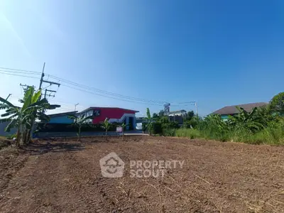 Spacious land plot with potential for development, surrounded by lush greenery and modern buildings.