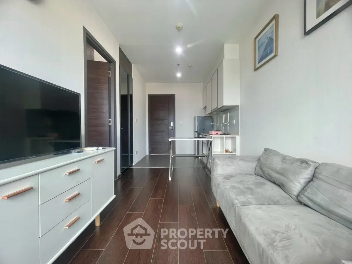 Modern living room with sleek furniture and wooden flooring in a stylish apartment.