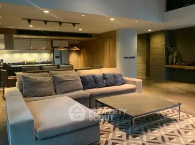 Spacious modern living room with stylish decor and open kitchen layout.