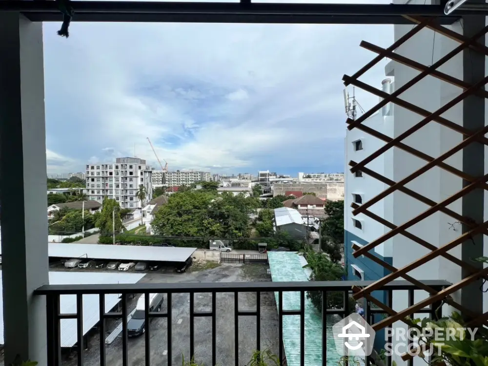 Stunning balcony view overlooking cityscape with lush greenery and modern buildings.