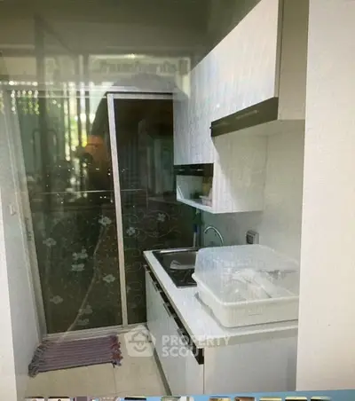 Compact kitchen with modern white cabinetry and sleek design in urban apartment.