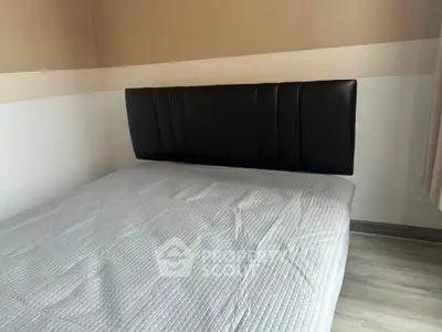 Cozy bedroom with modern headboard and minimalist design, perfect for relaxation.