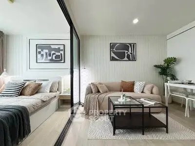 Modern open-plan living room and bedroom with stylish decor and neutral tones.