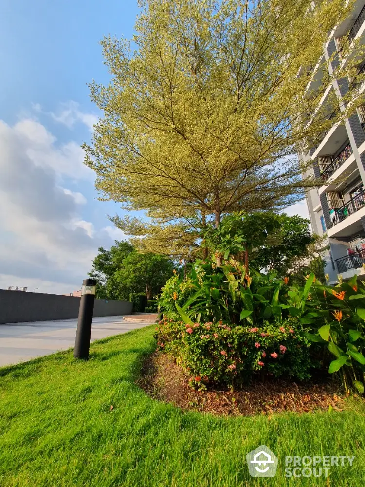 Lush green garden with vibrant plants beside modern apartment building